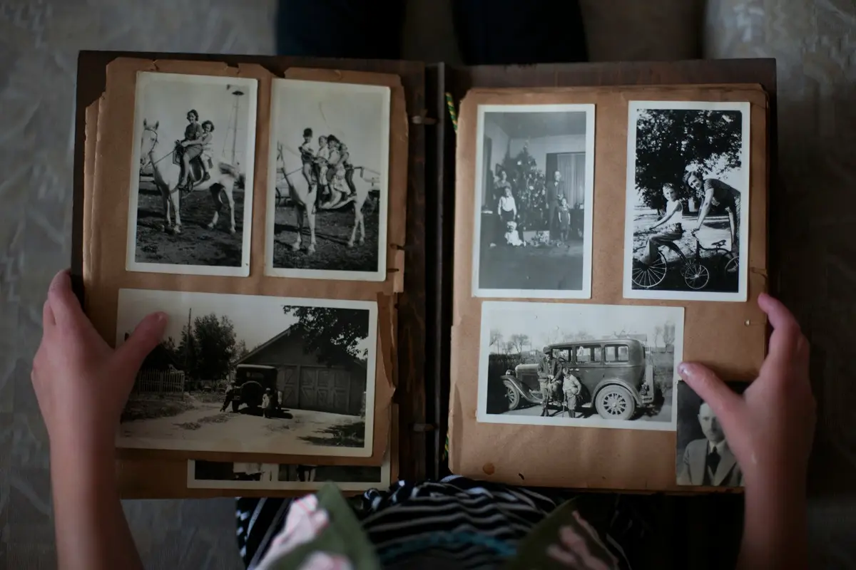 Hands opening an old family photo album