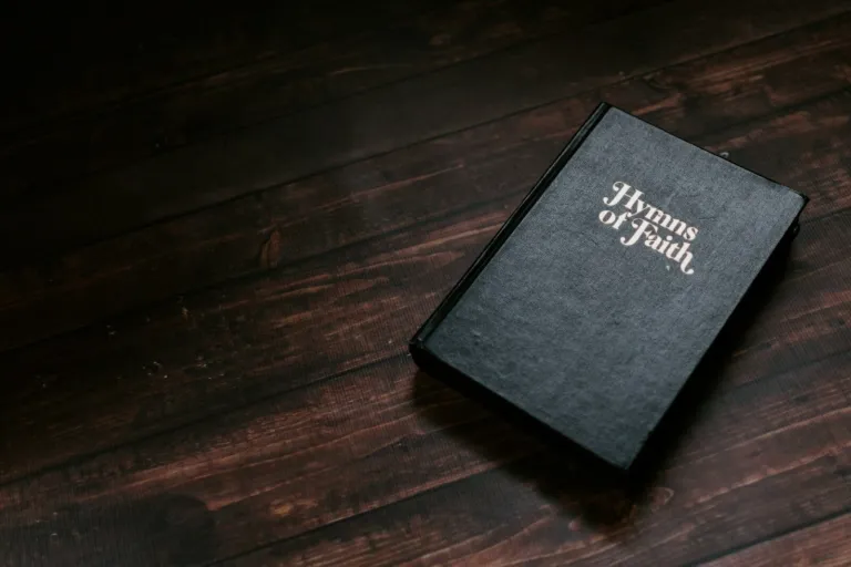A Hymns of Faith book on a wooden table